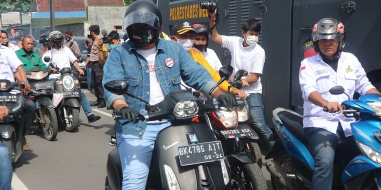 Muhammad Bobby Afif Nasution dan Aulia Rachman bersama rombongan partai pengusung konvoi menaiki Vespa menuju KPU Kota Medan untuk mendaftarkan diri sebagai bakal pasangan calon wali kota dan wakil wali kota Medan, Jumat (4/9/2020)