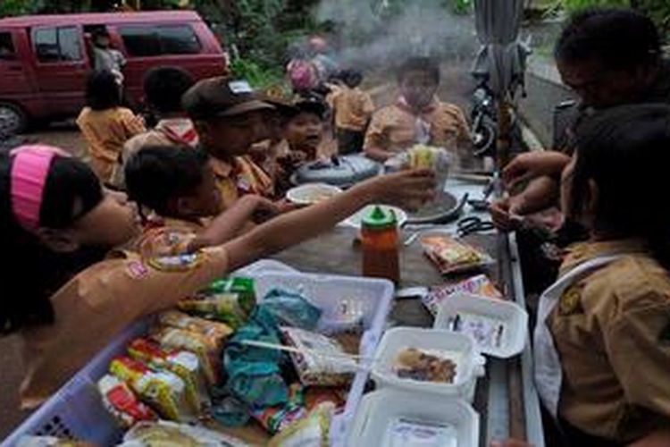 Murid-murid SD membeli jajanan saat jam istirahat di sekitar sekolah mereka di kawasan Kuningan, Jakarta, Rabu (20/2/2013). Jajanan sekolah yang tidak terjamin kebersihan dan keamanannya berpotensi menjadi penyebab gangguan kesehatan bagi anak-anak.
