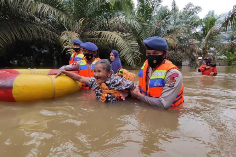 Personel Brimob Polda Riau mengevakuasi seorang nenek yang terjebak banjir di Kabupaten Inhu, Riau, Senin (19/4/2021).