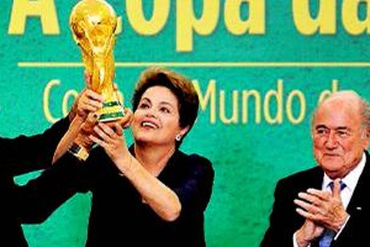 Mantan kapten tim nasional Brasil, Cafu, dan Presiden Brasil Dilma Rousseff mengangkat trofi Piala Dunia di samping Presiden FIFA Joseph Blatter (dari kiri ke kanan), di Brasil, Selasa (2/6).