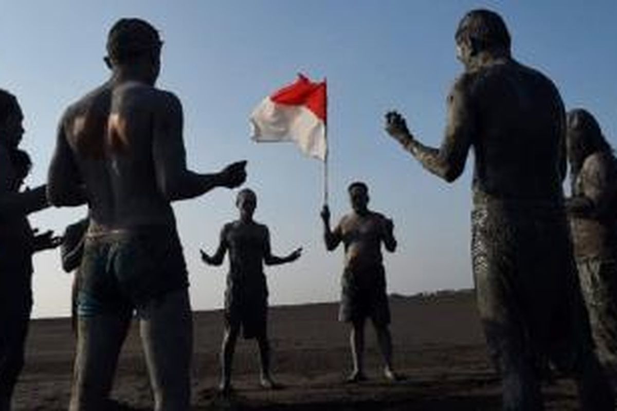 Warga bermandikan lumpur berdoa bersama saat aksi teatrikal, menyambut peringatan sembilan tahun semburan lumpur di kolam penampungan lumpur Lapindo, Kecamatan Porong, Sidoarjo, Jawa Timur, Minggu (24/5). Aksi teatrikal yang digagas seniman Dadang Crhristanto itu menggambarkan penderitaan serta perjuangan pantang menyerah warga korban lumpur.