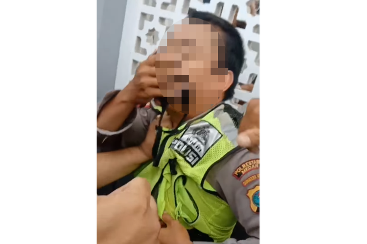 Tangkapan layar video yang menampilkan seorang oknum anggota polisi di Medan, Sumatera Utara, diamuk warga usai disebut memberhentikan seorang pengendara motor yang tidak melakukan kesalahan hingga meminta uang Rp 200.000.