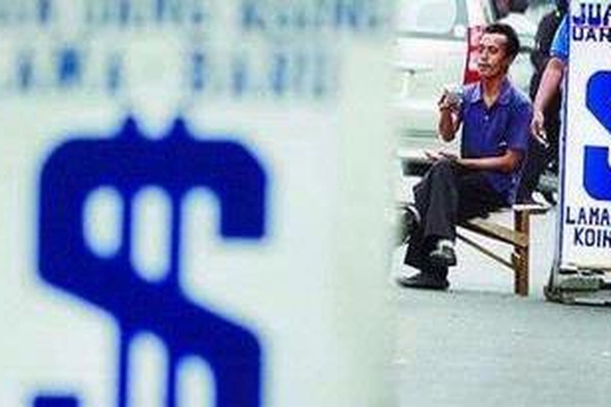 Pedagang mata uang asing menanti calon pembeli di kawasan Kwitang, Jakarta.