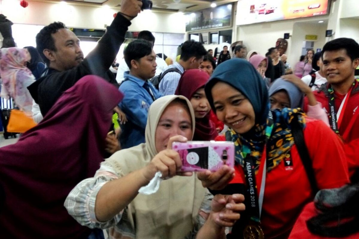 Salah satu atlet panjat tebing Indonesia Puji Lestari saat meladeni selfie warga di bandara Adisutjipto, Yogyakarta, Selasa (28/8/2018)