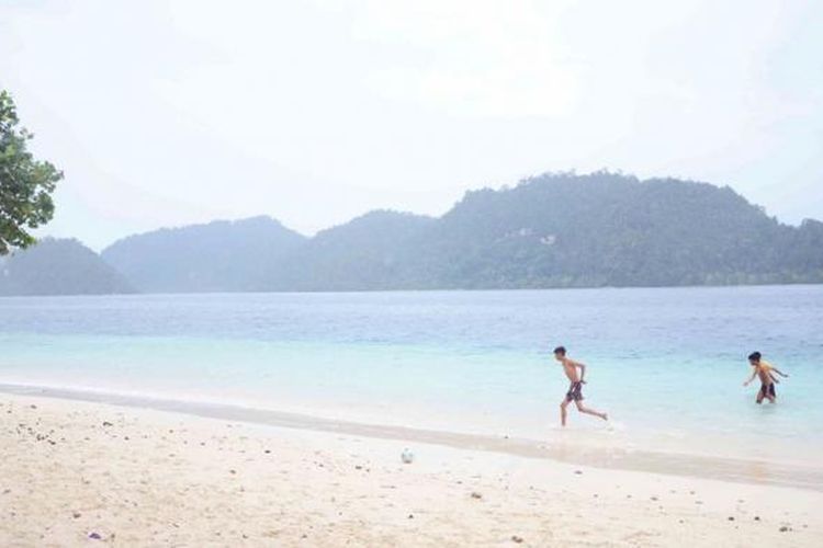 Keceriaan pengunjung saat menikmati keindahan alam dan kejernihan air di Pulau Pagang.