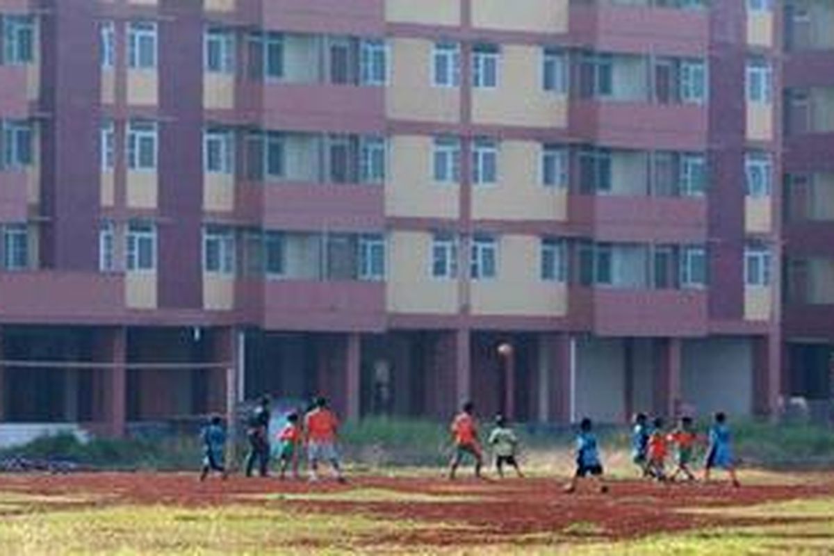 Anak-anak bermain bola di lahan kosong di samping rumah susun sewa Marunda di Cilincing, Jakarta Utara, Jumat (2/4/2010) silam. 