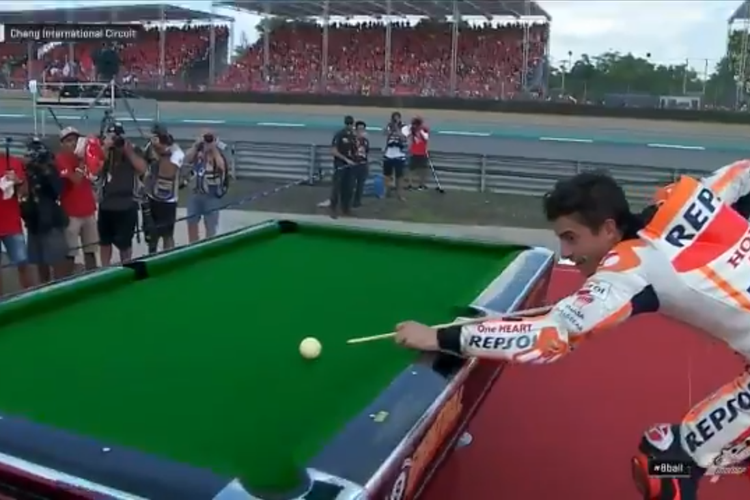 Pebalap Repsol Honda Team, Marc Marquez, merayakan gelar juara dunia 2019 dengan menyodok bola biliar angka 8 di sisi lintasan.