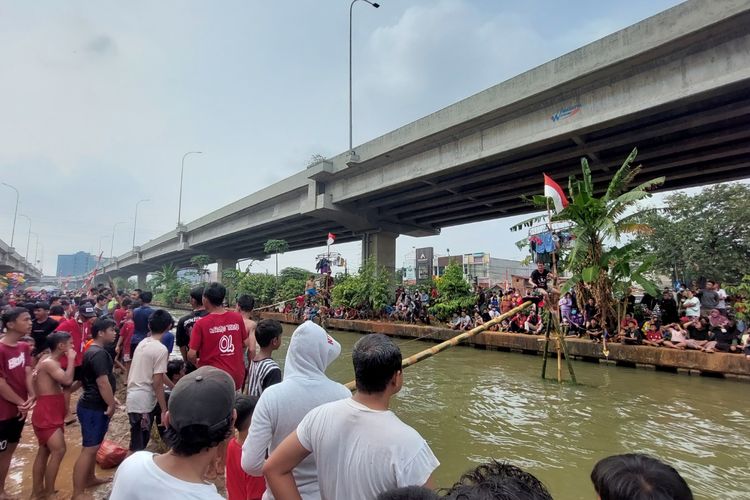 Suasana lomba panjat pinang yang berlangsung di aliran Kali Malang, RW04, Kelurahan Cipinang Melayu, Kecamatan Makasar, Jakarta Timur, Minggu (28/8/2022).