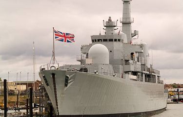 Ilustrasi bendera Union Jack di tonggak depan kapal.