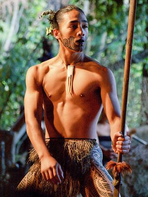 Seorang pria dari Suku Maori yang memiliki tato pada bagian wajah serta bawah tubuh.