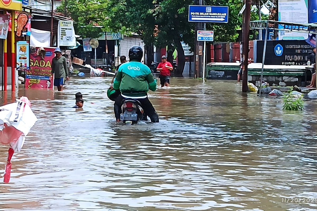 Seorang pengemudi ojol di Sidoarjo nekat terobos banjir demi antar pesanan warga yang kebanjiran, Kamis (20/11/2025).