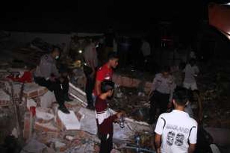 Warga, TNI dan polisi mencari korban yang diduga tertimbun direruntuhan bangunan di Ulee Glee, Kecamatan Bandar Dua, Pidie Jaya, Rabu (7/12/2016) malam