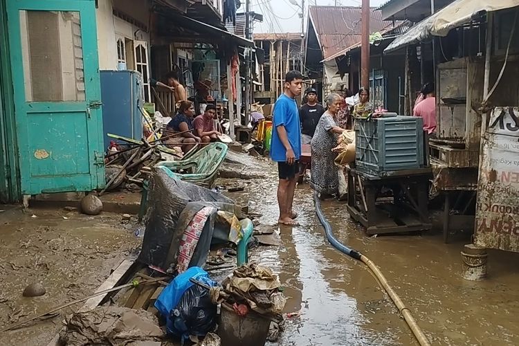 Sejumlah warga Lingkungan Kelurahan Aur, Kecamatan Medan Maimun, Kota Medan, Sumatera Utara, terlihat sedang membersihkan rumah setelah banjir surut, Jumat (28/11/2025).