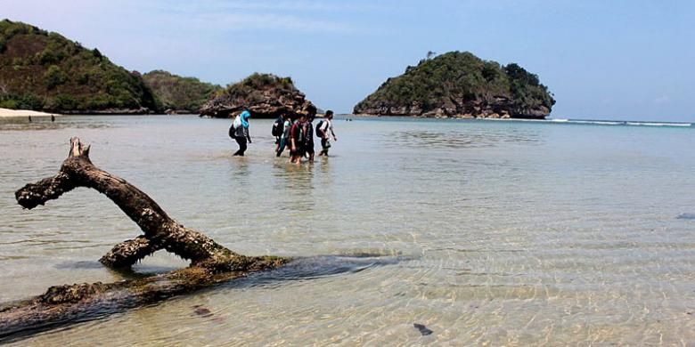 Pengunjung menyeberang laut di antara Pantai Gatra dan Pantai Clungup, Sabtu (8/8/2015). Pantai Clungup adalah salah satu pantai di Malang yang bisa dikunjungi untuk berlibur.