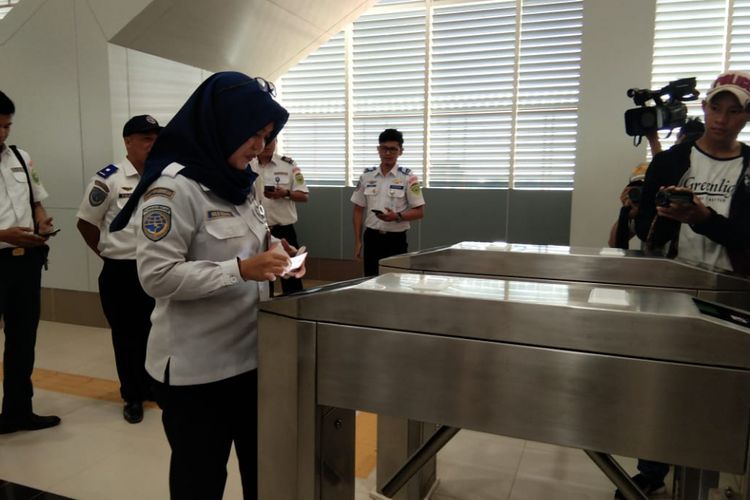 Seorang pegawai dari Dishub sumsel sedang tapping Tap Cash distasiun LRT Jakabaring Palembang, Senin (23/7/2018)