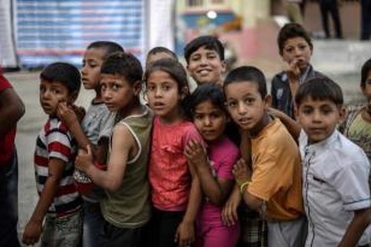 Anak-anak pengungsi Suriah berbaris untuk mendapatkan makanan berbuka puasa di Akcakale, di provinsi Sanliurfa, 20 Juni 2015.