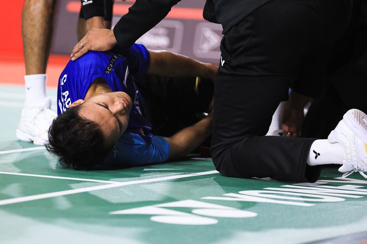 Tunggal putra Indonesia, Christian Adinata, saat memegang lutut setelah mengalami cedera dalam pertandingan melawan wakil India, Prannoy H.S, di semifinal Malaysia Masters 2023 pada Sabtu (27/5/2023).