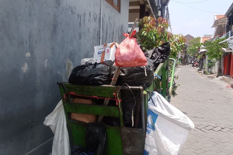 Gerobak dorong milik Pak Markan yang berisi sampah dari jalanan yang telah dipilah dan dikelompokkan di wadah kresek atau karung tertentu.