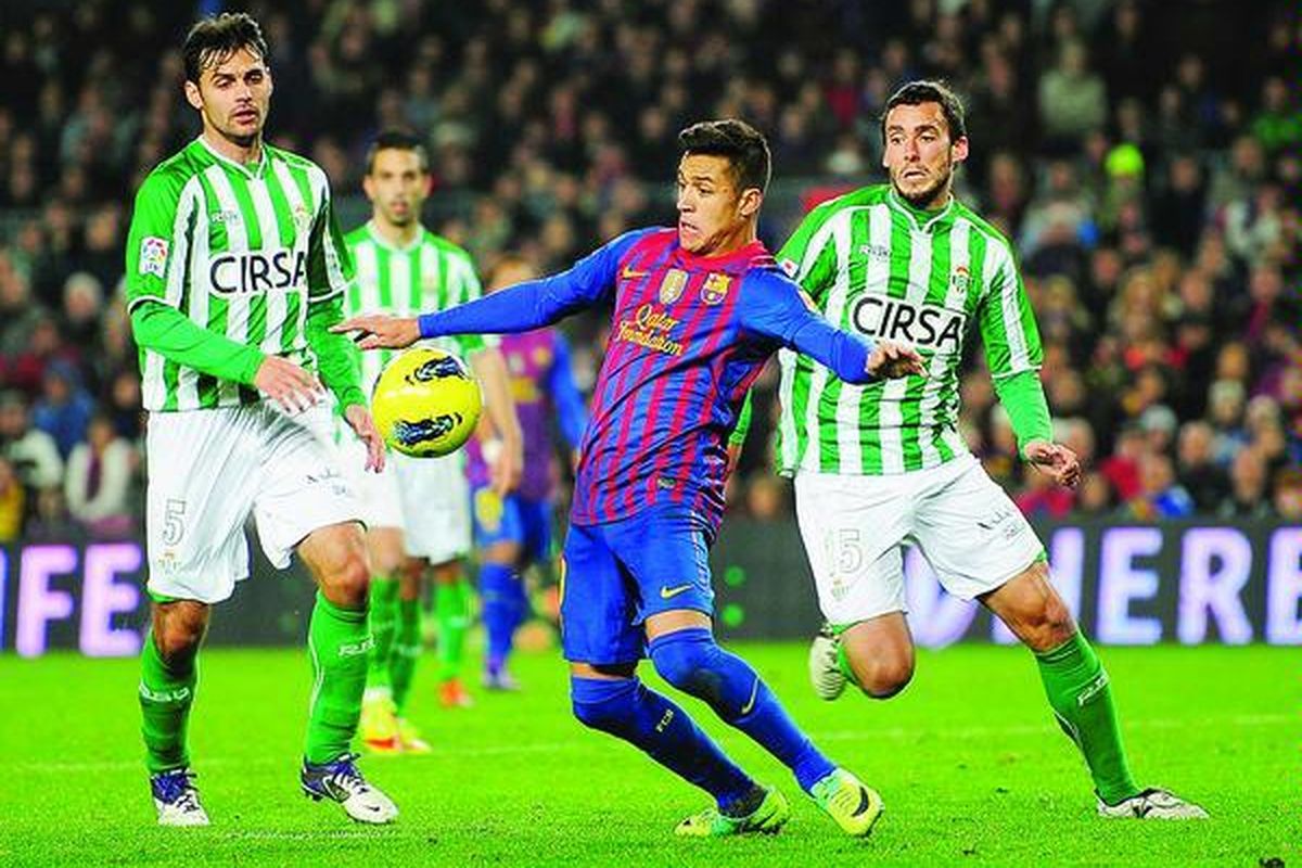 Pemain Barcelona asal Cile, Alexis Sanchez (tengah), berebut bola dengan pemain Real Betis, Ustaritz Aldekoaotalora, dalam laga Liga Spanyol di Stadion Nou Camp di Barcelona, Spanyol, Minggu (15/1). Barcelona menang 4-2.