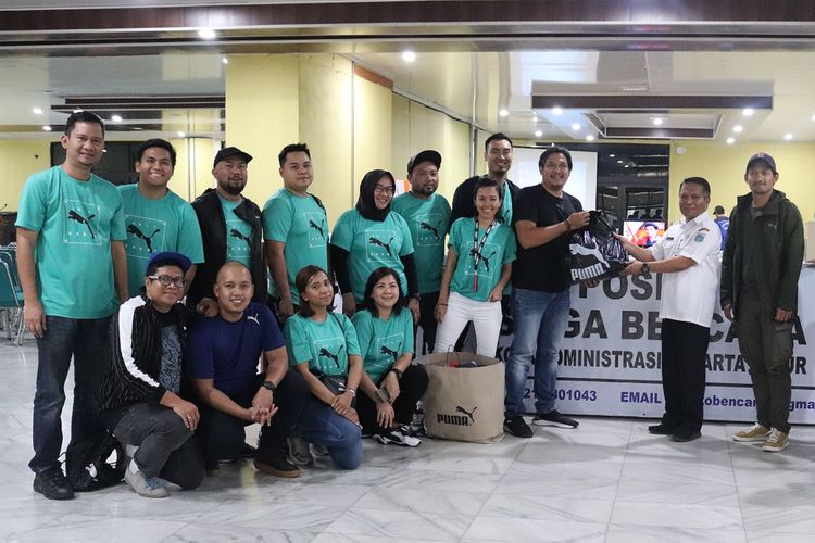Achyat Rachman, Country Manager Puma Indonesia (kaus hitam) menyerahkan bantuan untuk korban banjir kepada Wali Kota Jakarta Timur, M. Anwar (baju putih), Rabu (8/1/2020)