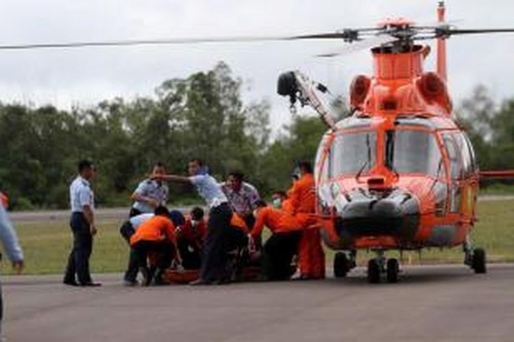 Petugas Basarnas membawa jenazah dari helikopter menuju ambulans di Posko Utama Pecarian Pesawat AirAsia QZ8501, Lanud Iskandar, Pangkalan Bun, Kalteng, Rabu (31/12/2014). Dua dari tujuh jenazah yang telah ditemukan berhasil dibawa ke posko untuk kemudian diidentifikasi di RSUD Sultan Imanudin. TRIBUNNEWS/DANY PERMANA