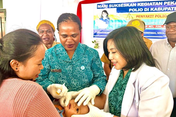 Ketua TP PKK Kabupaten Intan Jaya, Ancela Sondegau (tengah) saat memberikan imunisasi polio secara simbolis kepada seorang balita (27/5/2024).