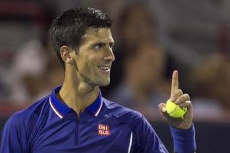 Petenis Serbia, Novak Djokovic tersenyum saat menjalani pertandingan babak kedua Rogers Cup melawan Florian Mayer, di Montreal, Selasa (6/8/2013).