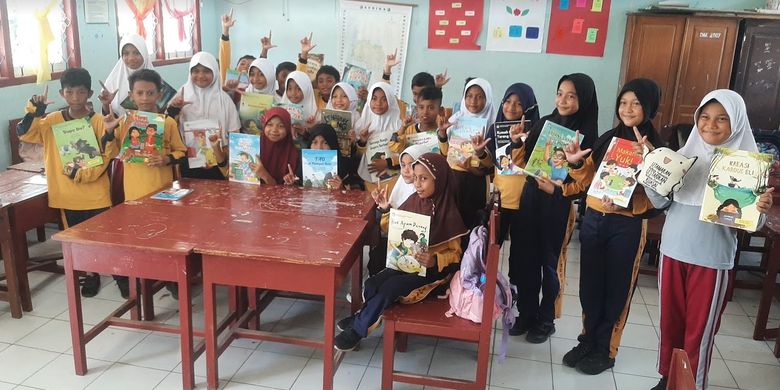 Anak-anak sekolah memegang buku bacaan bermutu dari Kemendikbud Ristek.
