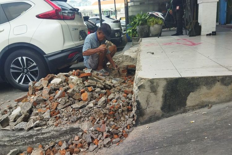 Salah satu tukang di ruko Z8 Selatan Nomor 9-11, Pluit, Penjaringan, Jakarta Utara yang tengah bekerja membongkar beton-beton di atas bahu jalan dan menutup saluran air. 