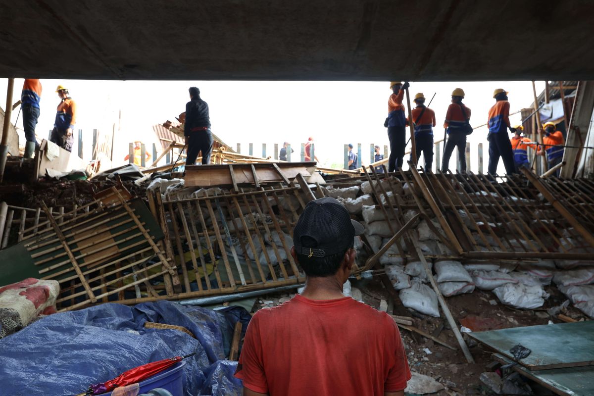 Warga menyaksikan pembongkaran kawasan lokalisasi Gunung Antang, Jakarta Timur, Selasa (30/8/2022). Petugas gaungan dari Satuan Polisi Pamong Praja (Satpol PP) Pemerintah Provinsi Jakarta Timur serta melibatkan personel TNI-Polri melakukan pembongkaran lokalisasi yang berdiri di lahan milik PT KAI.