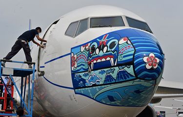 Pesawat Garuda Indonesia Boeing 373-800 NG dengan desain masker di bagian depan pesawat, saat diparkir di lapangan udara di Tangerang, Banten, Senin (12/10/2020). Pemasangan ''masker'' di pesawat tersebut digelar untuk mendukung kampanye Gerakan 'Ayo Pakai Masker' dalam rangka penanggulangan pandemi Covid-19.