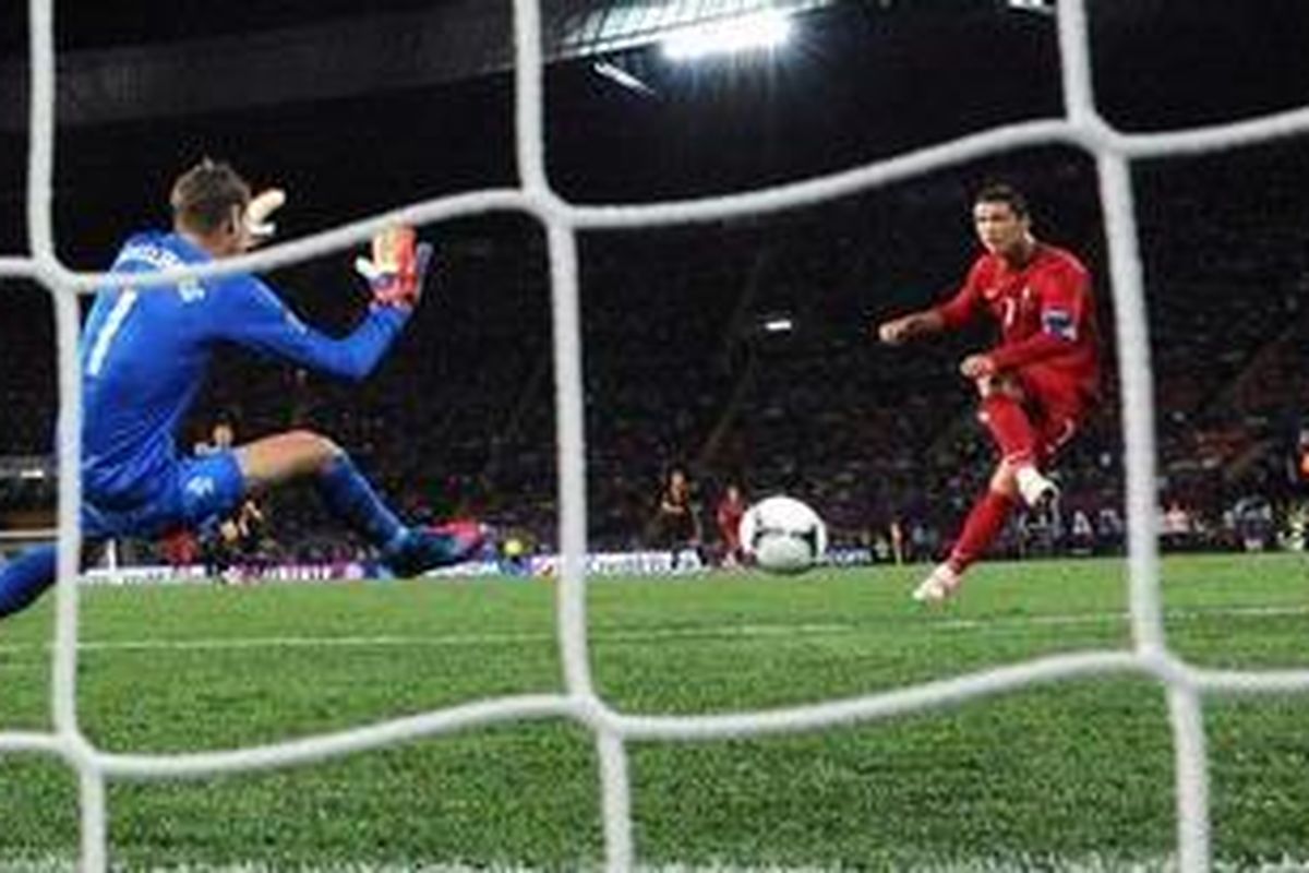 Gelandang Portugal, Cristiano Ronaldo (tengah), melepaskan tembakan, yang berujung gol keduanya (dari dua) ke gawang Belanda, pada matchday ketiga Grup B, di Metalist Stadium, Minggu (17/6/2012).