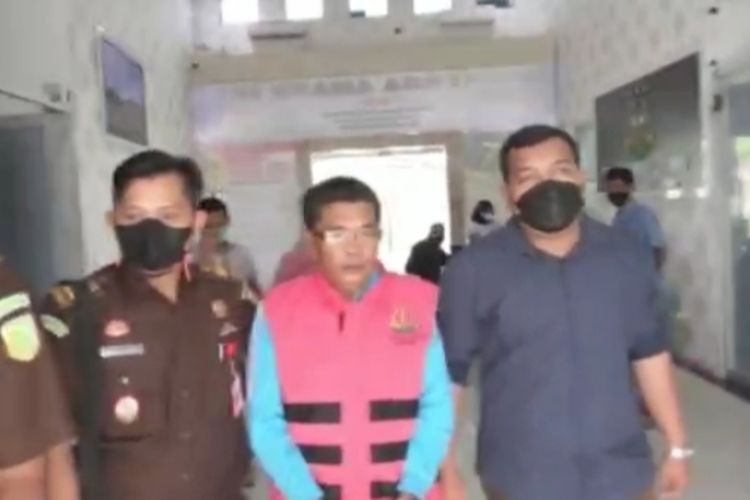 EH, mantan Camat Kampar Kiri Hilir saat digiring petugas Kejari Bangkinang menuju mobil tahanan untuk ditahan atas kasus dugaan korupsi, Rabu (15/12/2021).