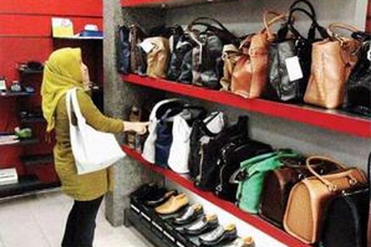 Seorang pembeli sibuk memilih tas yang dipajang di rak-rak House of Leather.