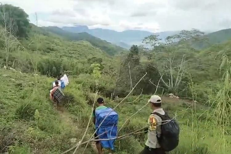 Perjuangan Bhabinkamtibmas mengawal dan mengamankan kotak suara ke PPK Kecamatan Seko bersama KPPS dan Linmas harus ditempuh dengan berjalan kaki dan menggendong di belakang kotak suara dengan melewati hutan di Desa Tirobali, Kecamatan Seko, Kabupaten Luwu Utara, Sulawesi Selatan, Kamis (22/2/2024)