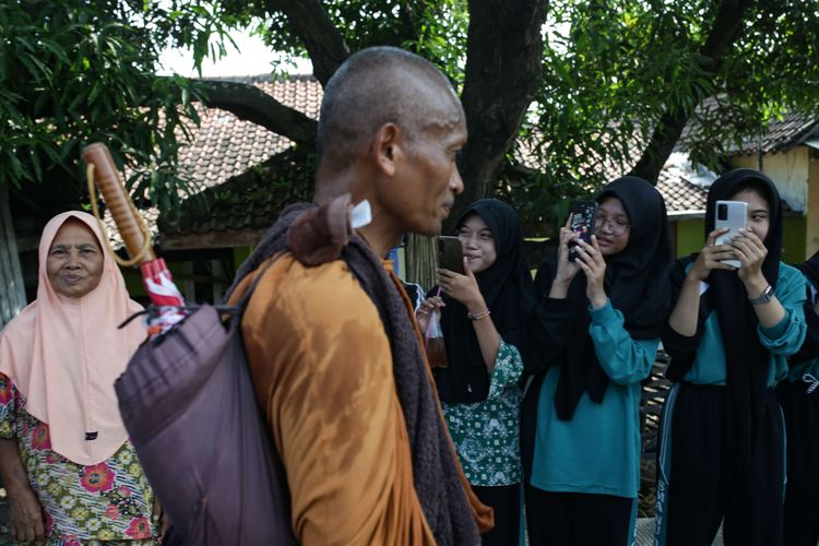 Antusias warga menyambut biksu yang melintas menjalani ritual thudong saat perjalanan dari Kota Tegal ke Pemalang, Jawa Tengah, Rabu (24/5/2023). Sebanyak 32 biksu jalan kaki dari Thailand menuju Candi Borobudur untuk meyambut Hari Raya Waisak.