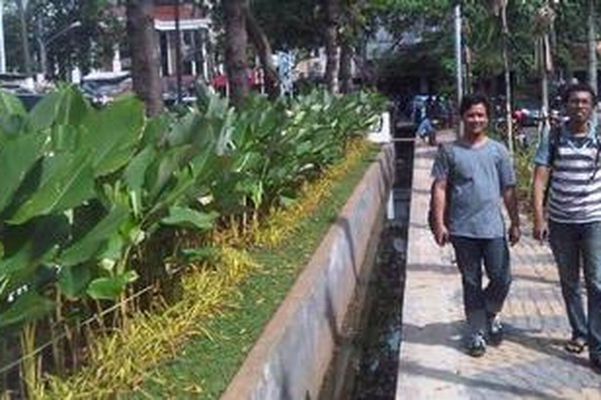 Dua orang tengah melintas di dekat Taman Rawa Kebo, Cempaka Putih, Jakarta Pusat, Selasa (14/5/2013). Tempat ini sering menjadi tempat pembuangan sampah dari pedagang yang berdagang di pinggir taman.