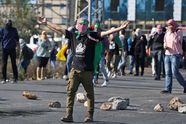 Warga Palestina bentrok dengan petugas keamanan Israel dalam aksi protes yang terjadi di Tepi Barat, Senin (11/12/2017).