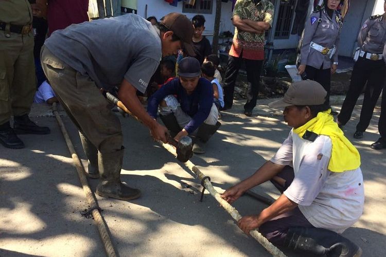 Pekerja memasang pita kejut di perlintasan KA tanpa palang pintu di Kelurahan Tirto, Kota Pekalongan, Jawa Tengah, Jumat (16/6/2017). 