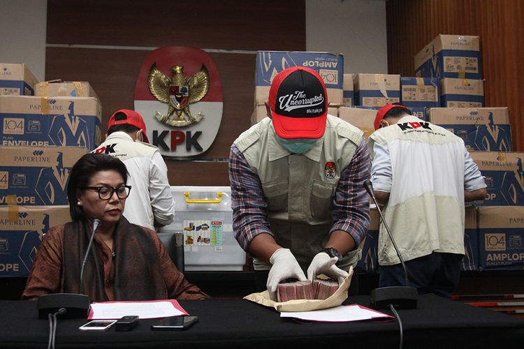 Penyidik didampingi Wakil Ketua KPK Basaria Panjaitan, menunjukkan barang bukti hasil operasi tangkap tangan (OTT) yang menjerat anggota DPR Fraksi Golkar Bowo Sidik Pangarso, saat memberikan keterangan pers, di Gedung KPK Merah Putih, Jakarta, Kamis (28/3/2019). Uang senilai Rp 8 miliar yang dibagi dalam 84 kardus atau 400 ribu amplop dengan pecahan Rp 20 ribu dan Rp 50 ribu tersebut diduga sebagai suap untuk pelaksanaan kerja sama Pengangkutan Bidang Pelayaran antara PT Pupuk Indonesia Logistik (PILOG) dan PT Humpuss Transportasi Kimia (HTK), dan diduga digunakan untuk membantu biaya kampanye 2019.