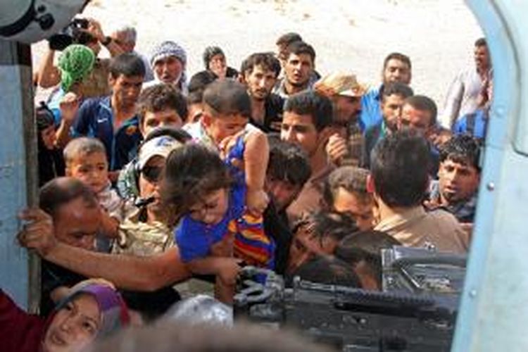 Warga kota Amirli mencoba menitipkan anak-anak dan para perempuan ke halikopter militer Irak yang membawa bantuan ke kota yang sudah dua bulan dikepung Negara Islam Irak dan Suriah.