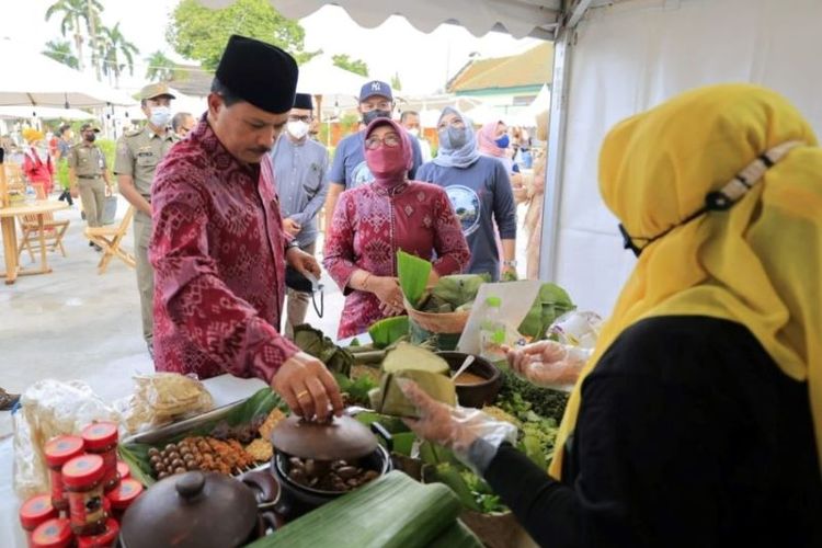 Wali Kota Madiun Maidi medatangi salah satu stan nasi pecel saat membuka kegiatan Festival Pecel Pincuk di Pahlawan Bisnis Center depan kantor Bakorwil I Madiun Jalan Pahlawan Kota Madiun, Selasa (3/5/2022). Festival Pecel Pincuk digelar selama momentum libur Lebaran 2022 sebagai upaya mengenalkan ikon kuliner khas kota setempat kepada para pemudik dan wisatawan yang berkunjung ke Kota Madiun. 