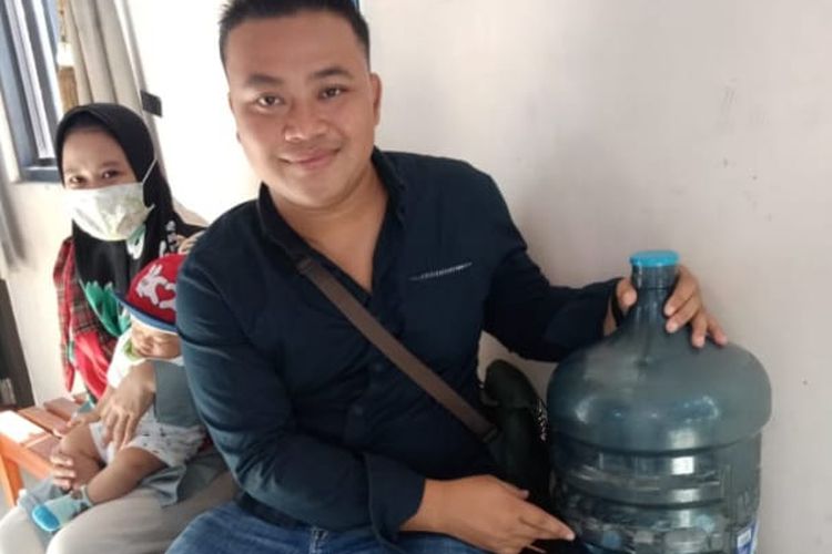 Satria memperlihatkan uang koin seribuan di sebuah galon bekas air minum