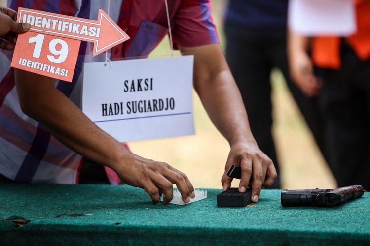 Kepolisian melakukan rekonstruksi kasus peluru nyasar di Gedung DPR RI di Lapangan Tembak Senayan, Gelora, Tanah Abang, Jakarta Pusat, Jumat (19/10/2018). Diberitakan sebelumnya, polisi menetapkan I (32) dan R (34) sebagai tersangka dalam kasus ini. Mereka ditangkap usai berlatih menembak di lapangan tembak Senayan pada Senin (15/10/2018).