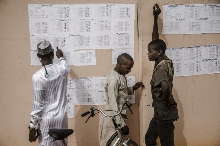 Penduduk Nigeria memeriksa nama mereka dalam daftar pemilih di Kantor Komisi Pemilu Independen (INEC) di Jimeta pada 16 Februari 2019. (AFP/LUIS TATO)