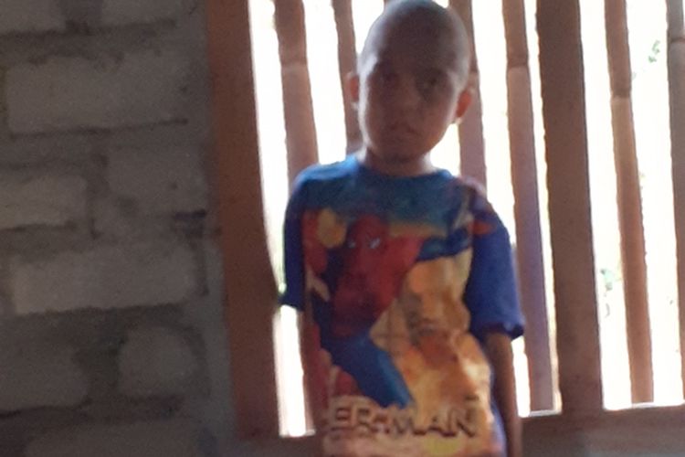 Aleksius Aleng(46) sedang berada disamping anak keenamnya, Antonius Fransisco Alen (8) yang menderita bocor ginjal di Kampung Sola, Desa Ruan, Kec. Kota Komba, Kab. Manggarai Timur, Flores, NTT, Jumat, (1/11/2019). (KOMPAS.com/MARKUS MAKUR)