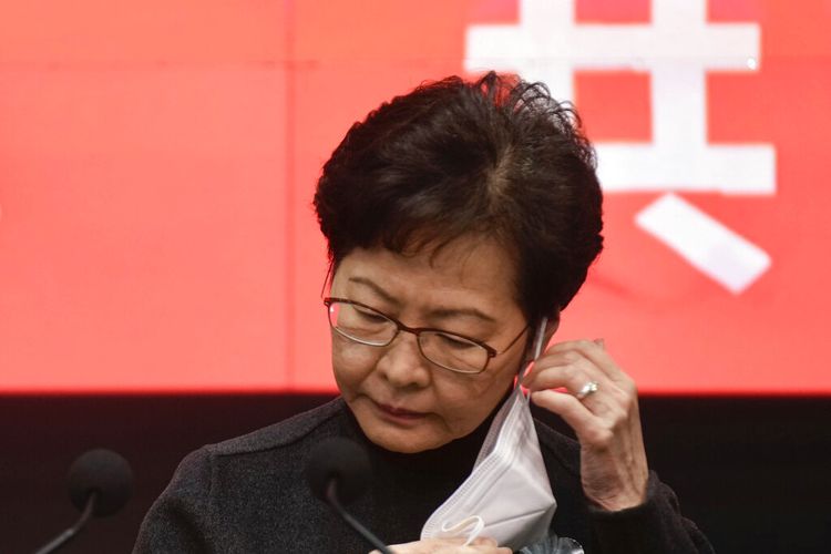 Kepala Eksekutif Hong Kong Carrie Lam melepas masker wajahnya sebelum konferensi pers di Hong Kong, Selasa, 22 Februari 2022. 
