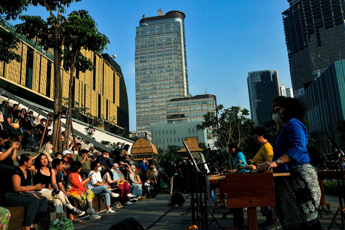 Sejumlah penonton menyaksikan penampilan grup musik Suara Cenderawasih saat tampil pada pagelaran musik di pelataran Mal Sarinah, Jakarta, Minggu (19/6/2022). Mal Sarinah menjadi salah satu destinasi liburan bagi warga Jakarta dan sekitarnya pada hari libur. ANTARA FOTO/Fakhri Hermansyah/nym.