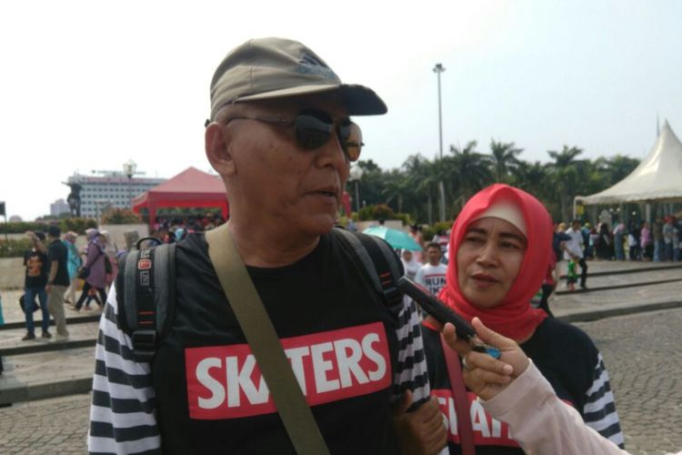 Suherman (58 tahun) dan Yati (50 tahun) wisatawan asal Subang, Jawa Barat menikmati Tugu Monumen Nasional (Monas) pada Minggu (9/7/2017). Tarif yang murah meriah menjadi salah satu daya tarik wisatawan Monas.