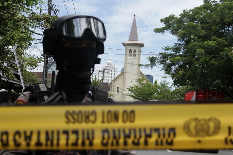 Anggota polisi berjada di ruas jalan menuju Gereja Katedral Makassar yang menjadi lokasi ledakan bom di Makassar, Sulawesi Selatan, Minggu (28/3/2021). Kapolda Sulawesi Selatan Irjen Pol Merdisyam mengatakan ledakan bom di gereja tersebut mengakibatkan satu korban tewas yang diduga pelaku bom bunuh diri serta melukai sembilan orang jemaat dan petugas gereja. ANTARA FOTO/Arnas Padda/yu/foc.